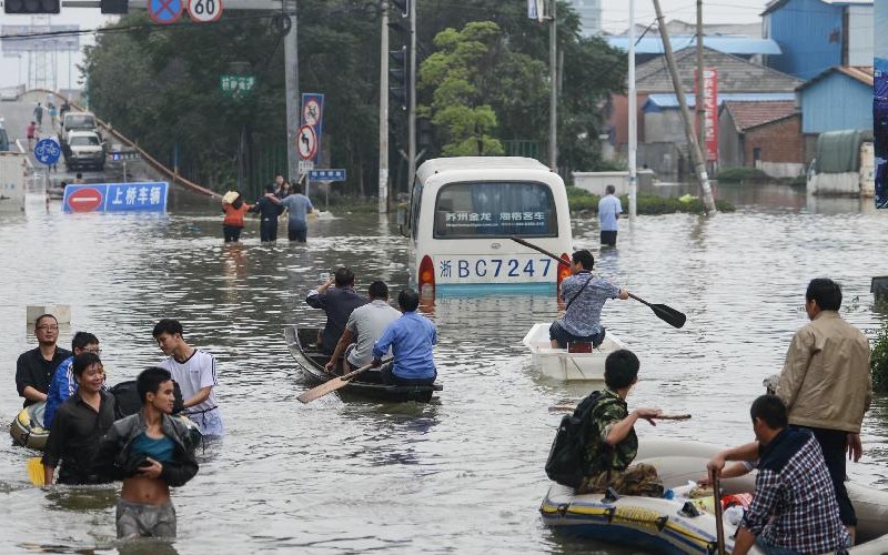 宁波余姚洪水中公交车被围困，市民乘小船通过积水道路